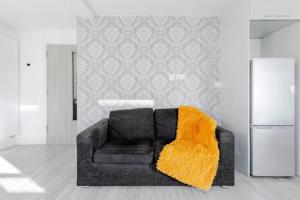sala de estar con sofá y manta naranja en #7 six sleeps Zone1 - BrickLane en Londres