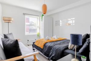 a bedroom with a bed and a couch at #7 six sleeps Zone1 - BrickLane in London