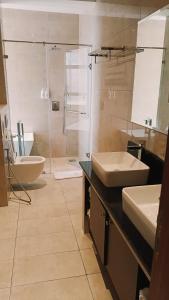 a bathroom with a shower and a sink and a tub at Lemaiyan Suites in Naivasha