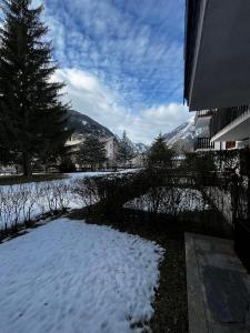 un patio cubierto de nieve con casas y una montaña en La casa di Ele, en Morgex 11 fotos más