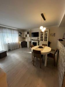 Una sala de estar con una mesa y un comedor. en La casa di Ele, en Morgex