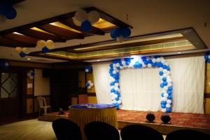 a stage with a blue and white balloon arch at Hotel Bishnu Palace in Jhārsuguda