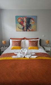 a bedroom with a bed with an elephant painting on the wall at Spa Serviced Apartments LUNA R&R 