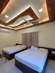 a room with two beds and a window at Royal Breeze Resort in Alibag