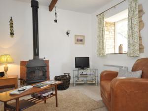 a living room with a wood stove and a couch at 1 Bed in Bourton-on-the-Water 44960 in Withington