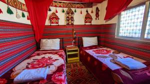 duas camas num quarto com paredes de listras vermelhas em Rocky Mountains Hotel em Wadi Musa