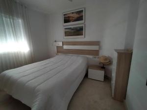 a bedroom with a large white bed and a window at Isla Cristina - 2 Dormitorios in Isla Cristina