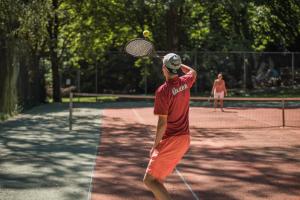 un hombre golpeando una pelota de tenis con raqueta en Jocomo Parc en Lanaken