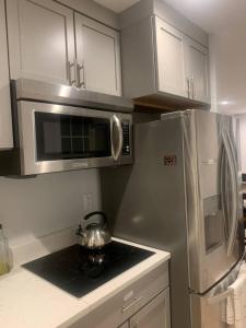 a kitchen with a stainless steel refrigerator and a tea kettle at Silver Spring Serene 2BR 2BA, Nature And Access in Silver Spring