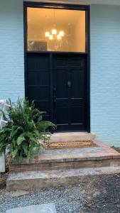 une porte d'entrée noire d'une maison avec une fenêtre dans l'établissement Tranquil Trio 6 BR, 4 BA, 3 Units, Deer Haven, à Silver Spring