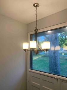a chandelier hanging in a room with a window at Tranquil Trio 6 BR, 4 BA, 3 Units, Deer Haven in Silver Spring