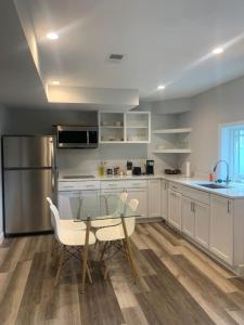 a kitchen with a glass table and a stainless steel refrigerator at Tranquil Trio 6 BR, 4 BA, 3 Units, Deer Haven in Silver Spring