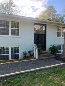 a white house with a black door at Tranquil Trio 6 BR, 4 BA, 3 Units, Deer Haven in Silver Spring