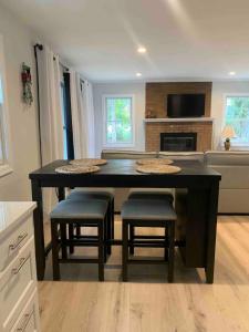 a kitchen with a large black table and stools at Serene Lush 2BR Gem, on 1 acre Silver Spring in Silver Spring