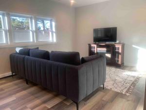 a black couch in a living room with a tv at Silver Spring Serene 2BR2BA, Nature And Access in Silver Spring