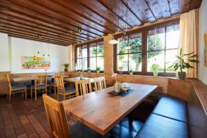 Flair Hotel Dobrachtal في كولمباخ: غرفة طعام مع طاولة وكراسي خشبية