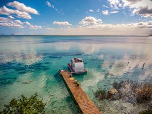 a boat in the water next to a dock at Bleibe- Quédate! in Bacalar