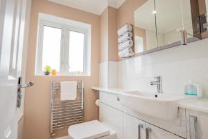 een witte badkamer met een wastafel en een toilet bij Guest Homes - Pirie Avenue in Worcester