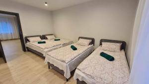 a room with three beds with green pillows on them at Sodyba Azagis in Vilkanastrai