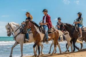 un grupo de personas montando a caballo en la playa en Seaside Serenity - Cozy Studio, en Luquillo