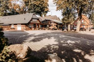 a log cabin with a road in front of a building at Akzent Hotel Zur Grünen Eiche in Bispingen