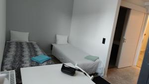 Kleines Zimmer mit 2 Betten und einem Tisch in der Unterkunft 2- bed Apartment in Sollentuna in Sollentuna
