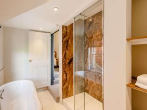 a bathroom with a shower with a glass door at 4 Bed in Welshpool 89012 in Llanfair Caereinion