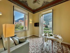 uma sala de estar com uma mesa e um sofá em [Villa Migliorini] Lusso & Comfort in Finalborgo. em Finale Ligure