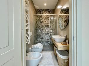 ein Badezimmer mit zwei Waschbecken, einem WC und einer Badewanne in der Unterkunft [Villa Migliorini] Lusso & Comfort in Finalborgo. in Finale Ligure