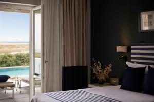a bedroom with a bed and a view of a pool at Summer Senses Luxury Resort in Logaras