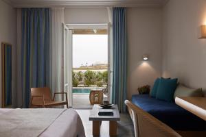 a hotel room with a bed and a view of a pool at Summer Senses Luxury Resort in Logaras