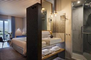 a bathroom with a bed and a sink and a shower at Summer Senses Luxury Resort in Logaras