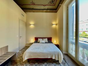 een slaapkamer met een bed en een groot raam bij [Villa Migliorini] Lusso & Comfort in Finalborgo. in Finale Ligure