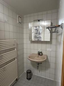 a white bathroom with a sink and a mirror at Haus Allgäu Ruh in Görisried