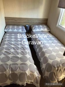 a bed in a small room with a bed sqor at BrookeView Caravan Rental, Seton Sands in Port Seton