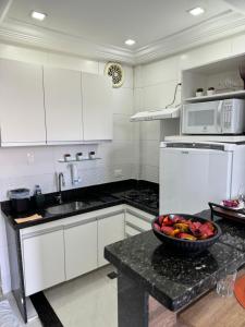 a kitchen with a bowl of fruit on a counter at Pé na areia in Rio de Janeiro