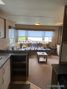 a kitchen and a living room with a couch at BrookeView Caravan Rental, Seton Sands in Port Seton
