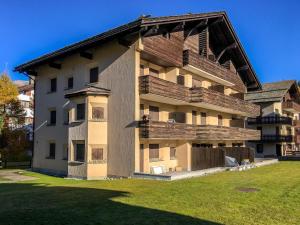 a large apartment building with a large balcony at Chesa Silvretta Duplex in Celerina