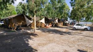 - un groupe de tentes et une voiture garée dans un parking dans l'établissement Glamping at Sardinia, à Alghero