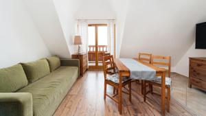 a living room with a green couch and a table at Kierpcówka, Sun & Snow in Kościelisko