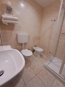 uma casa de banho com um WC, um lavatório e um chuveiro em I Monolocali Del Boccaccio em Milano Marittima