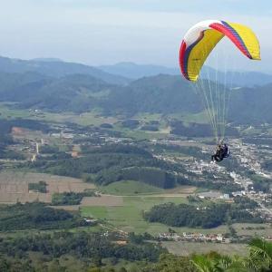 une personne sur un parachute volant en l'air dans l'établissement Morro Azul Chalés, à Timbó