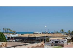einen Blick auf ein Gebäude mit Meerblick im Hintergrund in der Unterkunft Apartamento de 2 habitaciones en primera línea con vistas al mar in Platja de l'Arenal
