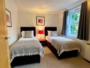 1 dormitorio con 2 camas y ventana en Your Space Apartments - Manor House, en Cambridge