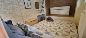 1 dormitorio con cama y pared de ladrillo en JK Luxury Old Town Apartment, en Tesalónica