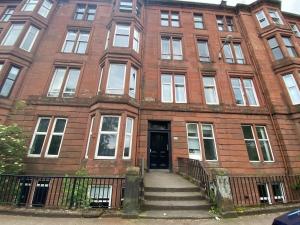 a red brick building with a staircase in front of it at Pass the Keys West End Studio Kelvingrove Park Museum in Glasgow