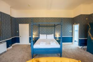 a bedroom with a blue bed with two pillows at Broome Park Hotel in Canterbury