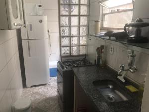 uma pequena cozinha com um lavatório e um frigorífico em Apto Olaria no Rio de Janeiro