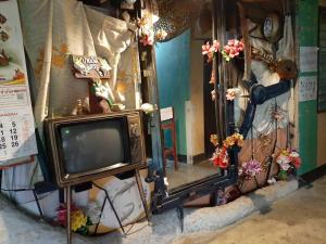 an old television sitting next to a mirror at Adchara Mansion in Chiang Rai