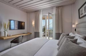 a bedroom with a bed and a desk and a window at Summer Senses Luxury Resort in Logaras